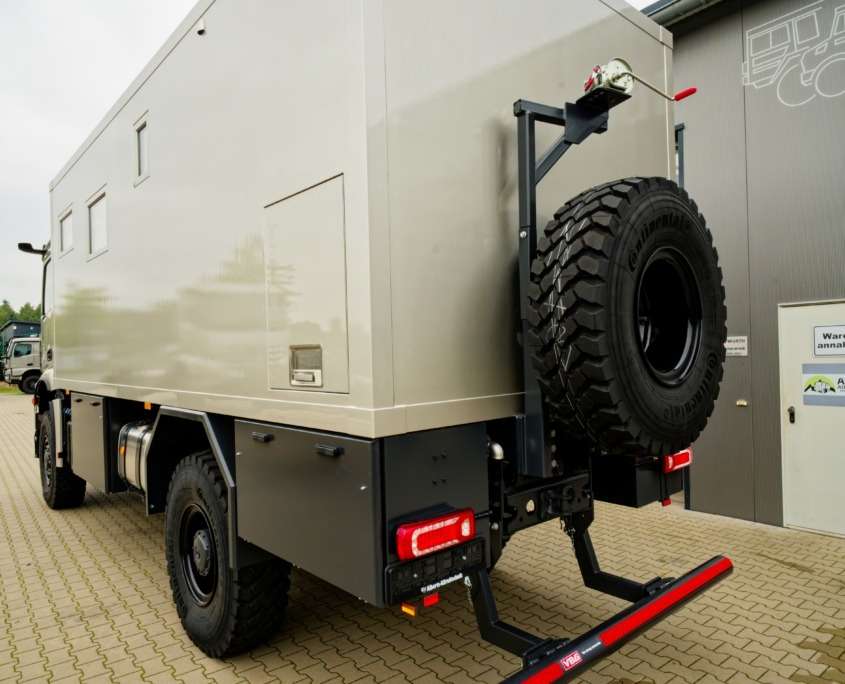 Expedition vehicle Alberts 60UQX rear view in front of the hall